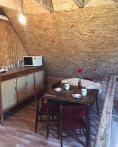 a dining room with a table with chairs and a microwave at Siedlisko Besarabka in Czernikowo