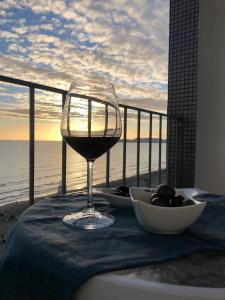 a glass of wine sitting on a table with a view of the ocean at viki sea view apartment in Durrës