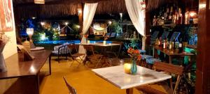 a restaurant with a table and chairs and a bar at Pousada Vila Mato Verde in Morro de São Paulo