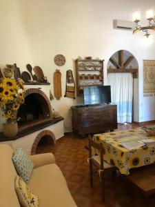 uma sala de estar com uma mesa e uma lareira em Villa Spiga & Serena em Porto Columbu - Perdʼe Sali