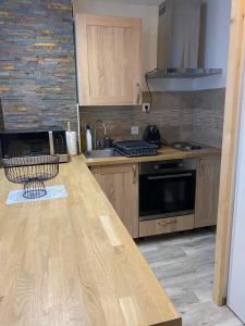 cocina con armarios de madera y encimera en Appartement Villard de Lans en Villard-de-Lans