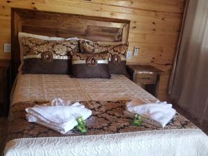 a bedroom with a bed with two towels on it at Cabana Frio da Serra in Urubici