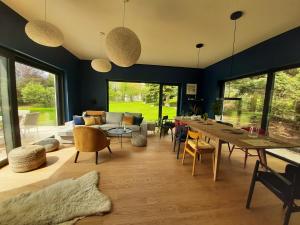 una sala de estar con una mesa larga y sillas en VILLA DANUTA- WISELKA, direct at National Park, big garden, 4 bedrooms, private SAUNA en Wisełka