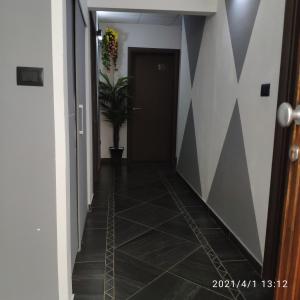 ジュリアノーヴァにあるB&B Adriaticoの黒いドアとタイル張りの床の廊下