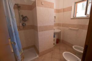 ein Bad mit einer Dusche, einem WC und einem Waschbecken in der Unterkunft Fondaco del Capo in Capo Vaticano