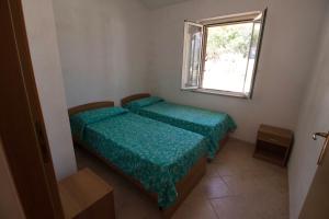 ein kleines Schlafzimmer mit 2 Betten und einem Fenster in der Unterkunft Fondaco del Capo in Capo Vaticano