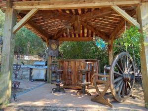 a wooden gazebo with a wooden wheel and chairs at Maison au Castellet in Le Castellet