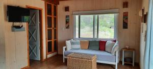 sala de estar con sofá y ventana en VILLA DEL SOL, en Punta del Diablo