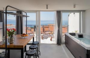 eine Küche mit Tisch und Blick auf das Meer in der Unterkunft Apartments Left & Right with jacuzzi, 4 stars in Makarska