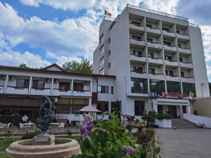 ein Gebäude mit einer Statue davor in der Unterkunft Hotel Spa Cazino Monteoru in Sărata-Monteoru