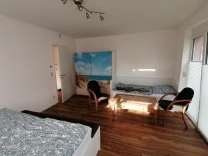 um quarto com 2 cadeiras, uma cama e uma mesa em 60qm 2 Raum Wohnung nahe dem Stadtzentrum em Rostock