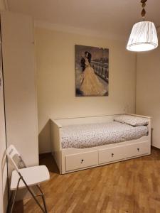 un letto in una stanza con un dipinto sul muro di CASA VACANZA COLOSSEO WHOLE HOLIDAY HOME APARTMENT da PAMINO & PRISCILLA a Roma