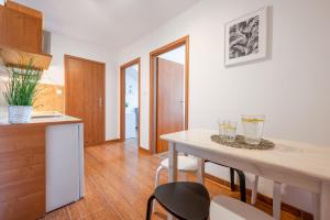 kuchnia i jadalnia ze stołem i krzesłami w obiekcie Apartamenty Plazowa w Darłówku