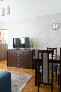 uma sala de estar com uma mesa e uma televisão num armário em Własne M-Studio CENTRUM parter em Konin