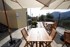 a wooden table with chairs and an umbrella on a balcony at Agriturismo Eos in Levanto