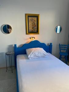 łóżko z niebieskim zagłówkiem w sypialni w obiekcie PKM Apartments Baska Voda w Baskiej Vodzie