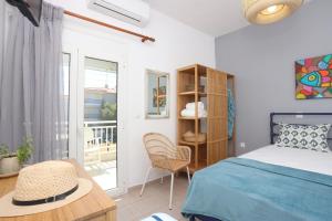 a bedroom with a bed and a table and a chair at BleVista Apartments in Polykhrono