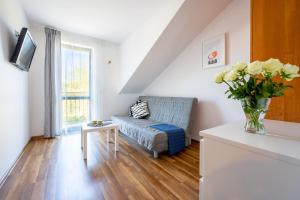 salon z kanapą i wazą kwiatów w obiekcie Apartamenty Plazowa w Darłówku