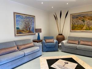 a living room with two blue couches and a table at Hotel Rombino in Fonteblanda