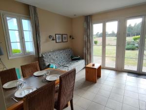 a living room with a table and chairs and a couch at Belle Dune Escale Nature in Fort-Mahon-Plage