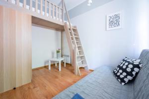 salon z łóżkiem na podwyższeniu i schodami w obiekcie Apartamenty Plazowa w Darłówku