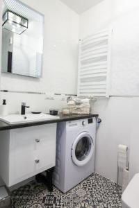 a bathroom with a washing machine and a sink at Apartament Blue Na Wydmach in Międzywodzie