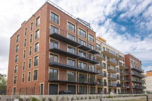 a brick building with balconies on the side of it at Apartament Blue Na Wydmach in Międzywodzie