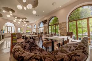 a restaurant with tables and chairs and windows at City Hotel in Piešťany