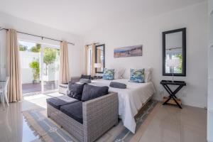un dormitorio con una cama y un sofá en Greenways Drive Apartment, en Kommetjie 32 fotos más