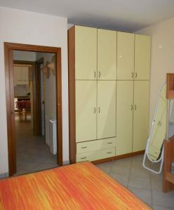 Un dormitorio con armarios blancos y una cama con escalera. en Apartment Rosolina Mare 5, en Rosolina Mare