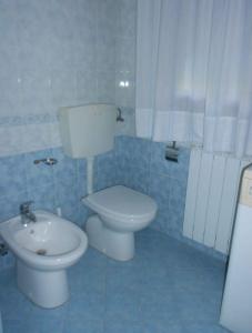 Un baño azul con inodoro y lavabo. en Apartment Rosolina Mare 5, en Rosolina Mare