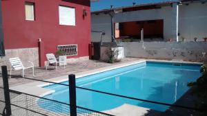 a swimming pool in front of a house at Amanitas Posada in Villa Carlos Paz