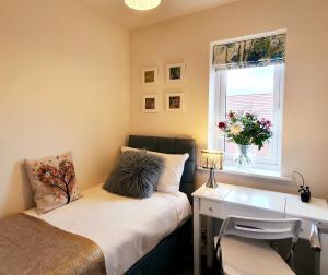 - une chambre avec un lit, un bureau et une fenêtre dans l'établissement Meadow View, luxury home in heart of England, à Shirebrook