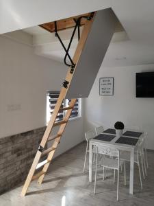 Una escalera de madera en un comedor con mesa en Ady Apartmanház, en Orfű