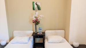 dwa krzesła i stół z wazonem kwiatów w obiekcie Helvetia Plus B&B w Warszawie