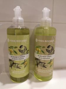 two bottles of olive fight germ sunscreen sitting next to each other at Antracit Apartman in Pécs