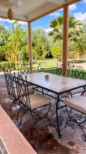 a table and chairs sitting on a patio at Ilafe Farmhouse, Villa avec piscine chauffée privée et Jacuzzi pour familles in Marrakesh