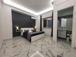 a bedroom with a king sized bed and a marble floor at GioRi in Giardini Naxos