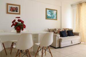 een woonkamer met een bank en een tafel en stoelen bij BEACH VILLAGE PRAIA DO FUTURO 904NORTE in Fortaleza