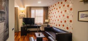 ein Wohnzimmer mit einem Sofa und einem Schreibtisch in der Unterkunft Hotel Jarun in Zagreb