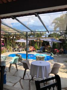 a patio with a table and chairs and a pool at Relais Amadeus Pousada de Charme in Pirenópolis