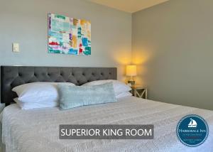 a bed in a bedroom with a sign that says superior king room at Harborage Inn on the Oceanfront in Boothbay Harbor