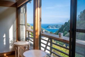 a room with a balcony with a view of the ocean at プライベートリゾート 月灯 in Atami