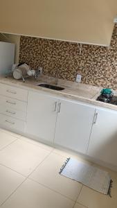 a kitchen with white cabinets and a sink at Casinhas da Vila - Itacaré in Itacaré