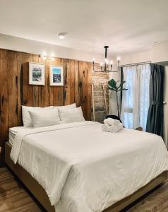 a large white bed in a bedroom with wooden walls at Petite Dalat - Boutique Hotel in Da Lat
