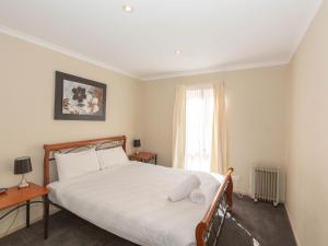 a bedroom with a large bed and a window at Acacia 5 2 Kirwan Close in Jindabyne