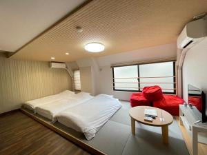 a small room with a bed and a table at Guest House Laule'a Tennoji in Osaka