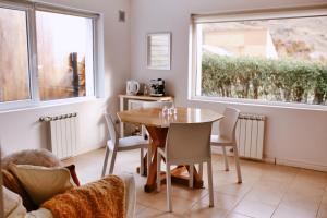 a dining room with a table and chairs and a window at Aguila Mora Aparts in El Chalten