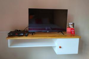 a television sitting on top of a wooden table at RedDoorz near Agrowisata Kebun Teh Dieng in Wonosobo