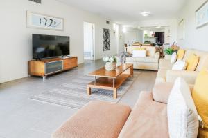 a living room with a couch and a tv at Avalon 114 Beachside Holiday Apartment in Agnes Water